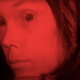 A red-toned image of Sissy Spacek as Carrie White in the horror movie Carrie.